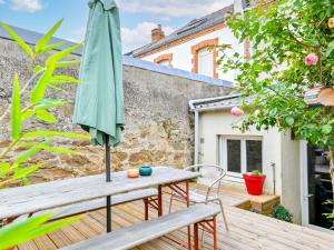 a patio with an umbrella and a wooden bench at La Casse Dorée - Terrasse & Gare à proximité in Cholet