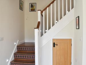 a hallway with stairs with a wooden door at White Heather Barn in Swanwick