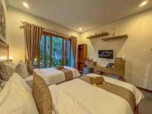 a bedroom with two beds and a window at Singabu Bungalows in Nusa Penida
