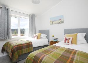 a bedroom with two beds and a window at Clear Sky Lodge Park in Falstone