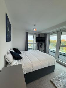 a bedroom with a large bed and a window at Luxury 1 bedroom Apartment, large balcony with Views Town Centre in Stevenage