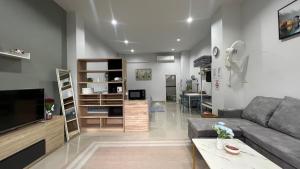 a living room with a couch and a tv at hidden loft, 5 mins to Songklanagarind Hospital โรงพยาบาลมอ หาดใหญ่ only 4 people in Hat Yai