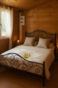 a bedroom with a bed with a flower on it at Charmant chalet au cœur de la Sologne in Villefranche-Sur-Cher
