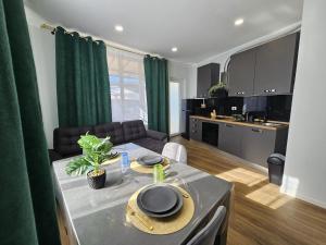 a kitchen and a living room with a table and a couch at Villa Kristin Residence in Monfalcone