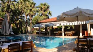 een zwembad met een tafel en een parasol bij Nirvana Hotel in Göcek