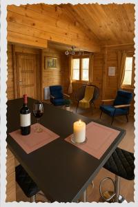 a table with a candle and a bottle of wine at Charmant chalet au cœur de la Sologne in Villefranche-Sur-Cher