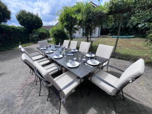 a black table with white chairs around it at Villa NovaTerra - Zeewolde in Zeewolde