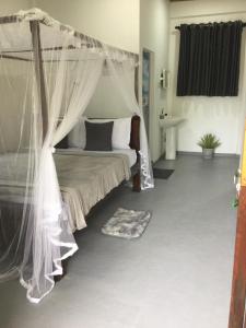a bedroom with a bed with a canopy at Sun Ray Beach Villa in Ranna