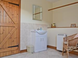 une salle de bain avec un lavabo et un réfrigérateur dans l'établissement Hope Cottage, à Knighton