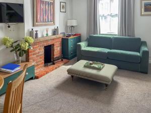 a living room with a couch and a fireplace at Willow Cottage in Stockbridge