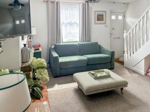 a living room with a blue couch and a table at Willow Cottage in Stockbridge