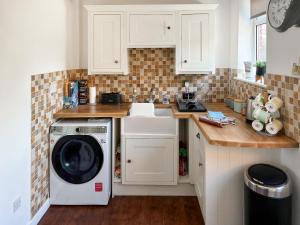 a kitchen with a washer and dryer on a counter at Willow Cottage in Stockbridge +5 photos