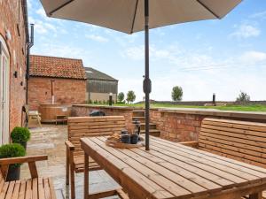 a wooden table with an umbrella on a patio at The Granary - Uk46002 in Rotsea +17 photos