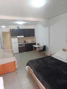 a bedroom with a bed and a table and a kitchen at Holiday and Business Home in Áyios Vasílios