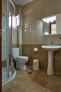 un baño con inodoro y lavabo en Villa Agiolina, en Sidari 57 fotos más