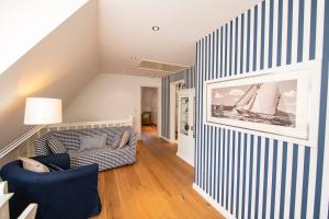 una sala de estar con una pared de rayas azules y blancas en Reethaus 1799, en Wyk auf Föhr