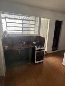 a kitchen with a stove and a sink at Quarto 001 - Centro de Valença in Valença