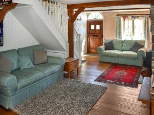 ein Wohnzimmer mit 2 Sofas und einer Treppe in der Unterkunft Primrose Cottage in Seaton