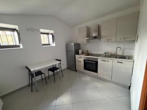 una piccola cucina con tavolo e frigorifero di Civico24rooms a Caltagirone