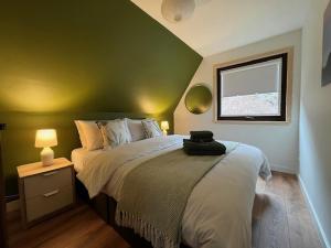 a bedroom with a large bed with a green wall at Knoydart - Uk50499 in Kylestrome