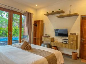 a bedroom with a large bed and a television at Singabu Bungalows in Nusa Penida