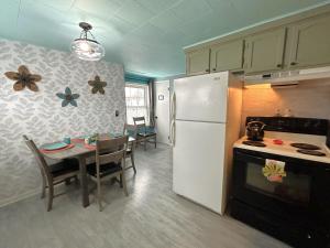 Una cocina con una mesa y un refrigerador blanco. en Bayview #1, en Saint Ignace