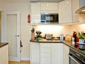 a kitchen with white cabinets and a counter top at Oldway Apartment in Paignton