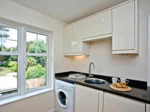 a kitchen with a sink and a washing machine at Oldway Apartment in Paignton +11 photos