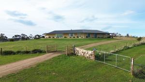 una casa in cima a una collina con una recinzione di Bruny Horizon - Where the Country meets the Sea a Killora Altre 6 foto