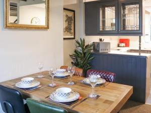 Una mesa de madera con platos y copas de vino encima. en Hafanedd, en Dyffryn