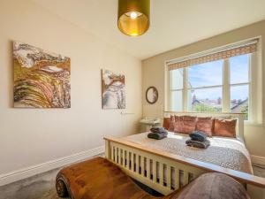 a bedroom with a large bed and a window at Olveston in Llandudno