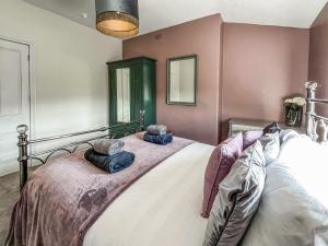 a bedroom with a large bed with two pillows on it at Olveston in Llandudno