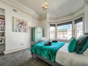 a bedroom with a bed with a blue blanket on it at Olveston in Llandudno +8 photos