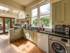a large kitchen with a washer and dryer in it at Olveston in Llandudno