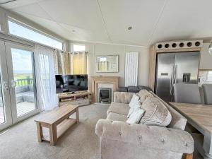 a living room with a couch and a television at Stunning Caravan With Full Sea Views At Broadland Sands In Suffolk Ref 20236Bs in Hopton on Sea