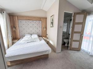 a bedroom with a large bed and a bathroom at Stunning Caravan With Full Sea Views At Broadland Sands In Suffolk Ref 20236Bs in Hopton on Sea +14 photos