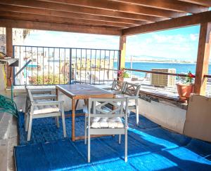 a table and chairs on a balcony with a view of the ocean at Nov Antique - AKKO in Acre