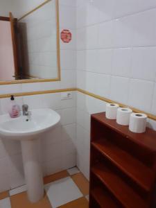 a bathroom with a sink and a mirror and rolls of toilet paper at tenerife only rooms near to beach in Los Cristianos +3 photos