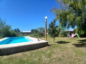 a swimming pool in a yard with a playground at Casa Aguaribay- Lomas Altas- in Chascomús