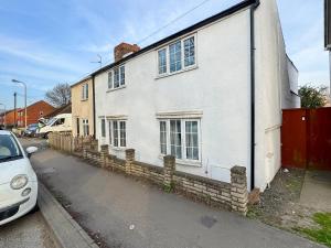 a white house on the side of a street at Riverside Cottage in Pinchbeck