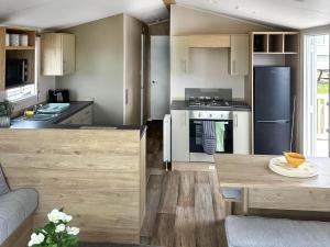 a kitchen with white appliances and wooden cabinets at Waterside Lodge in Tunstall