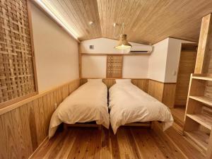 two beds in a room with wooden floors at Matsu no Yu Tokiwa - Vacation STAY 56390v in Yatsushiro