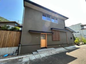 a gray house with a door and a fence at Matsu no Yu Tokiwa - Vacation STAY 56390v in Yatsushiro
