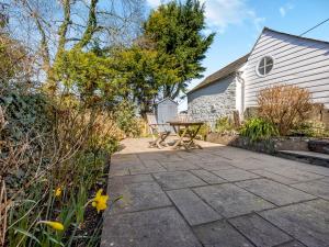 a patio with a table and chairs next to a building at Jarvies Cottage in Boscastle