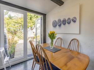 a dining room with a wooden table and chairs at Jarvies Cottage in Boscastle +14 photos