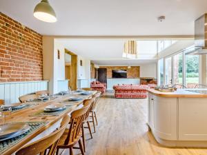 een grote eetkamer met een lange tafel en stoelen bij Fred's Barn in Swanton Abbot