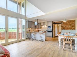 een keuken en woonkamer met een tafel en stoelen bij Fred's Barn in Swanton Abbot