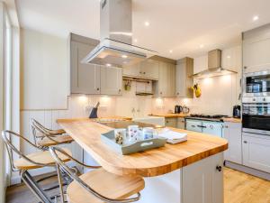 een keuken met een houten tafel en stoelen bij Fred's Barn in Swanton Abbot