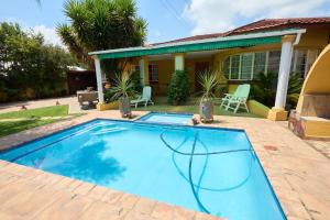 a swimming pool in front of a house at Twin Palms Guest House in Potchefstroom