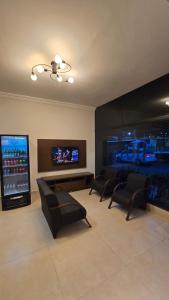 a living room with couches and a flat screen tv at Hotel Barretos Express in Barretos